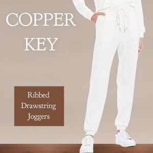 COPPER Key Ribbed Drawstring Jogger Pants with Pockets in Off White.